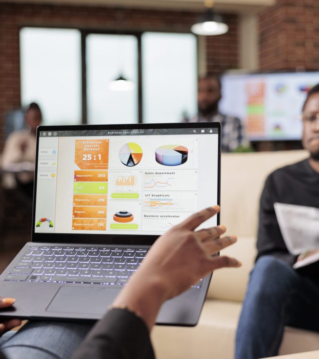 African american business people analyzing company charts and diagrams on laptop to create startup presentation and paperwork report. Doing teamwork collaboration to plan research information.